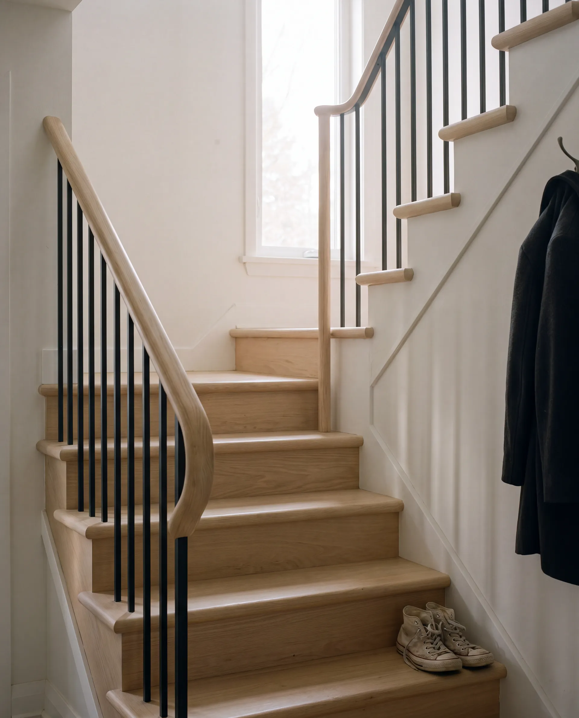 Escalier quart tournant en frêne clair avec garde-corps en acier noir